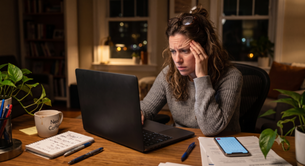 Woman searching for homes on her computer with frustrated look